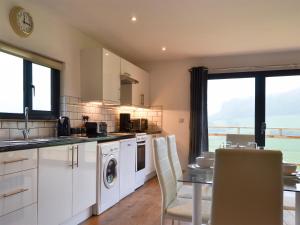 a kitchen with white cabinets and a table with chairs at Offa's Dyke Lodge - Uk10835 in Old Radnor