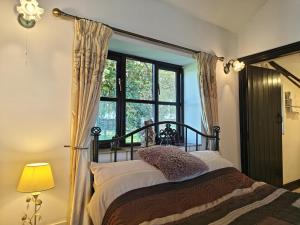 um quarto com uma cama com uma janela grande em 1 Bed in Yaxham oc-w33631 em Yaxham