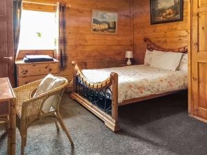 a bedroom with a bed and a desk and a chair at Cow Boy Cabin - Uk47145 in Glasgow +5 photos
