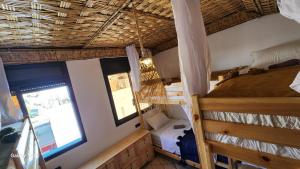a room with a bunk bed and a window at Rock Surf Hostel Taghazout in Taghazout