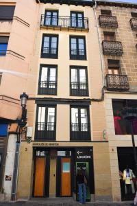 une personne debout devant un bâtiment dans l'établissement Apartamentos Marqués de Abastos, à Logroño