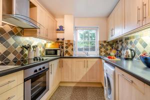 een keuken met houten kasten en een raam bij 2 Bed in Broad Haven oc-h33632 in Broad Haven