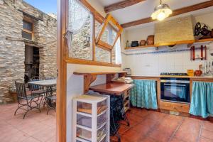 Una cocina con una encimera y una mesa dentro. en Casa Rural Masdenverge, en Masdenverge