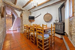 Un comedor con mesa y sillas y chimenea. en Casa Rural Masdenverge, en Masdenverge