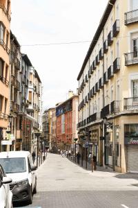 a city street with cars parked on the street at Apartamentos Marqués de Abastos in Logroño