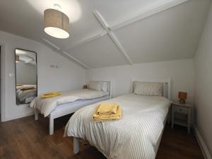 2 Betten in einem weißen Zimmer mit Spiegel in der Unterkunft 2 Bed in Fincham oc-t33561 in Fincham