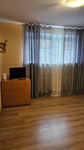 a living room with a window with curtains and a dresser at MINiLUx in Ventspils