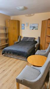 a bedroom with a bed and a table and chairs at MINiLUx in Ventspils