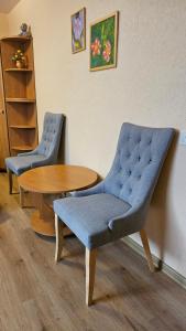two blue chairs and a table in a room at MINiLUx in Ventspils