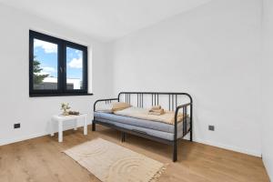 a white bedroom with a bed and a window at BNB Family Living Hviezdoslavov in Hviezdoslavov