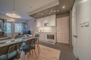 レヴィにあるLevin Stara A6 Visit Leviのテーブルと椅子のあるキッチンとリビングルーム