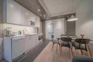 レヴィにあるLevin Stara A6 Visit Leviの白いキャビネットとテーブルと椅子のあるキッチン +3枚の写真