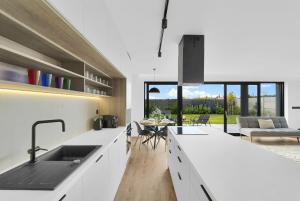 a kitchen with white countertops and a living room at BNB Family Living Hviezdoslavov in Hviezdoslavov