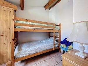 two bunk beds in a room with a lamp at L'Ulysse - 5pers - Climatisation - plage à 200 m in Narbonne