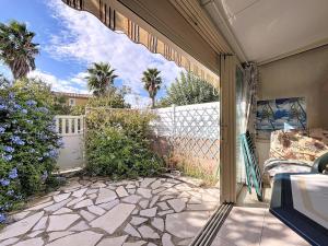 a patio with a white fence and a bed and a porch at L'Ulysse - 5pers - Climatisation - plage à 200 m in Narbonne