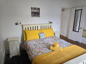 a bedroom with a bed with yellow sheets and yellow pillows at Beautiful Seafront 1 bedroomed apartment in Aberystwyth