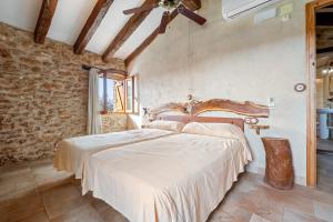 Un dormitorio con una cama y un ventilador de techo. en Cirerers - Casa Rural, en Masdenverge