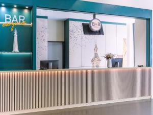 a lobby with a bar with a clock on the wall at B&B Hotel Aalen in Aalen +22 photos