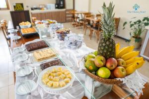 een lange tafel met een buffet met fruit en snacks bij Vila Olaria Hotel in Penha
