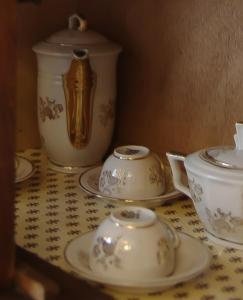 a table with three tea pots and saucers on it at B&B I Cherubini in Cislago
