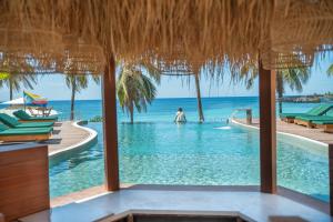 a person in the swimming pool at a resort at Naya Lodge in Mitsamiouli