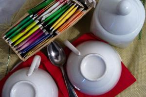 un groupe de crayons colorés sur un plateau rouge avec une cuillère dans l'établissement B&B I Cherubini, à Cislago