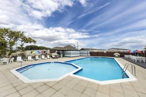 a large swimming pool on a patio with tables and chairs at 13 West Drive in Warsash