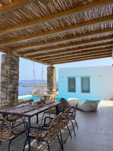 a table and chairs on a patio with a view of the ocean at Villa Cycladic View Syros in Azolimnos Syros