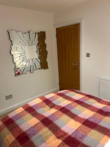 a bedroom with a plaid blanket on a bed at Kielder Station Master's House in Kielder