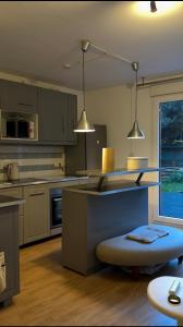 a kitchen with a counter and two pendant lights at Chambre privée chez l habitant Jardin et Transats in Noisy-le-Sec