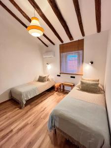two beds in a room with wooden floors at Casa Campo 10 min de Puy de Fou in Guadamur
