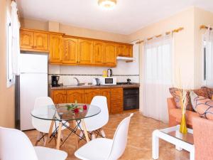 a kitchen with a glass table and white chairs at Live La Caleta Las Salinas con vista al mar 2 in Caleta de Interián