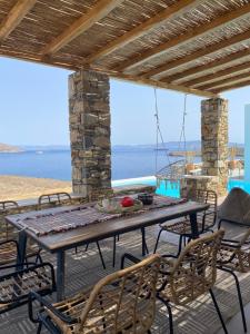 アゾリムノスにあるVilla Cycladic View Syrosのテーブルと椅子と海のあるパティオ