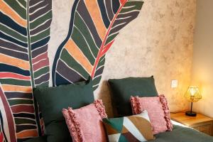 a room with a couch with pillows and a wall at Le Repère du Douanier - Séjour pro, calme et cosy in Mayenne