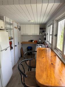 a kitchen with a wooden table and chairs in a trailer at Eco good vibrations in Algarrobo