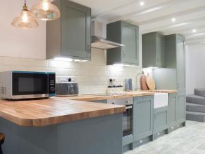 a kitchen with green cabinets and a counter top at Middle Hanter - Uk37355 in Old Radnor