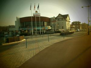 a building with flags in the middle of a street at Le Cottage in Villers-sur-Mer