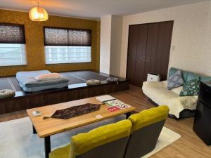 a living room with a table and a couch at SakuraPiso in Kagoshima