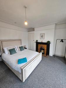 a bedroom with a large bed and a fireplace at The Folkestone One in Folkestone +15 photos