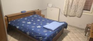 a bed with a blue blanket with white stars on it at Kounis Villa in Chalkida