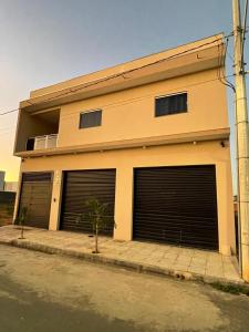 a building with two garage doors on a street at Essenza Lounge in Montes Claros +26 photos