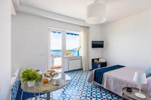 una habitación de hotel con una cama y una mesa en Blumare Amalfi Coast, en Maiori