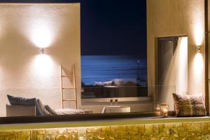 Golden Bay Suites & Maisonettes في بارغا: مرآة على جدار غرفة مع حوض