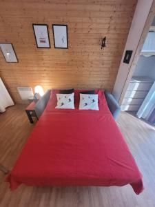 a bedroom with a large red bed with two pillows at Appartements Ski Spa & Confort Orelle-3 vallées in Orelle +76 photos