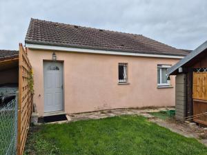 a house with a white door and a fence at Maison chaleureuse au calme in Domérat