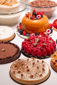 a table topped with cakes and other desserts at Hôtel Métropole Monte-Carlo - Spa Guerlain in Monte Carlo