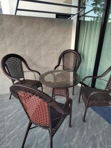 een glazen tafel en stoelen op een patio bij Waan Samui Pool Villa 2 in Taling Ngam Beach