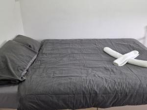 een bed met twee witte objecten erop bij Solid Mirror Home Milton Keynes in Bletchley