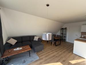 a living room with a couch and a table at FeWo Foorden Wohnglück 4 in Hesel +3 photos