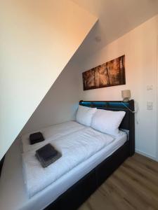 a bed with white sheets and pillows in a room at FeWo Foorden Wohnglück 4 in Hesel